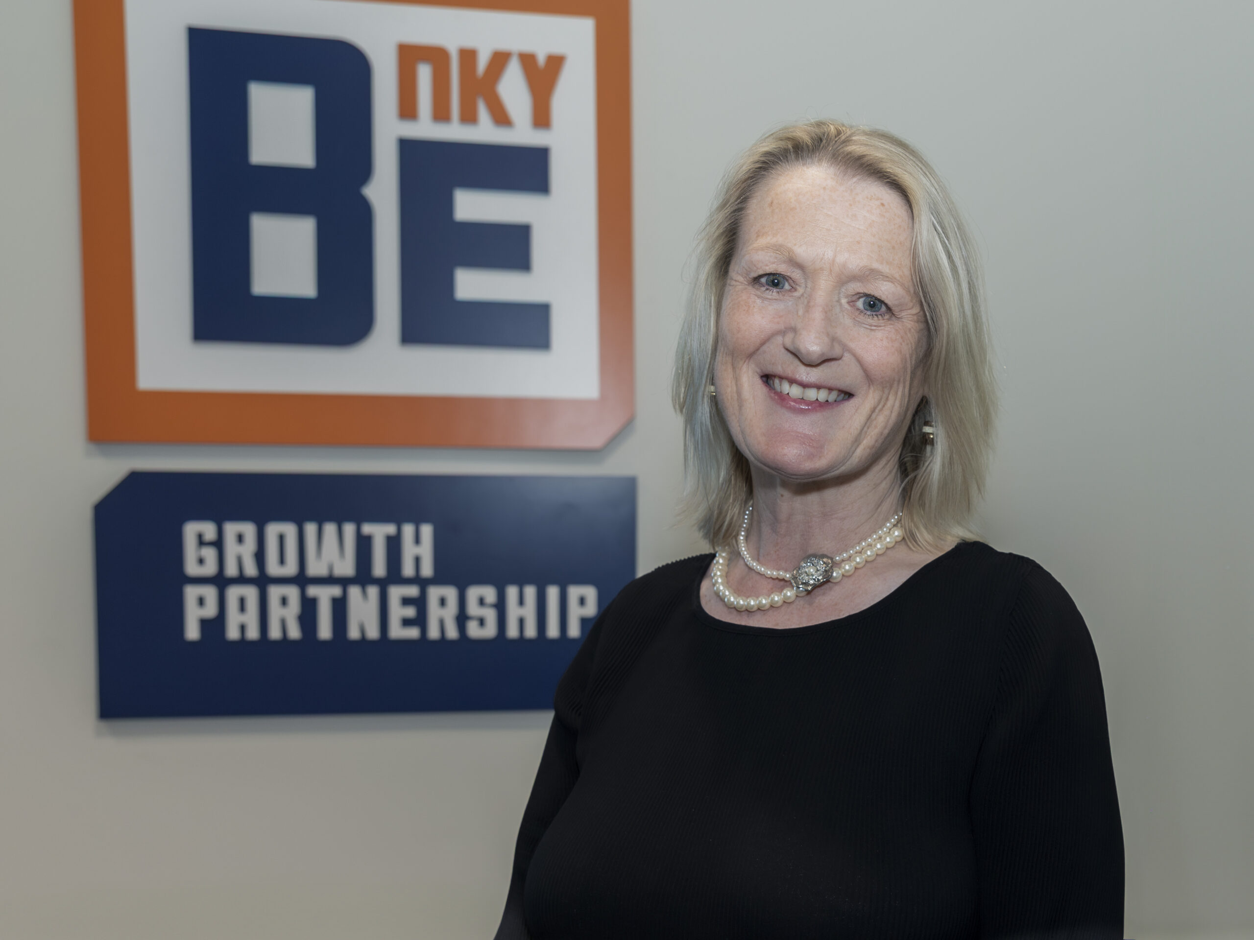 Lorraine O'Moore standing in front of BE NKY Growth Partnership sign