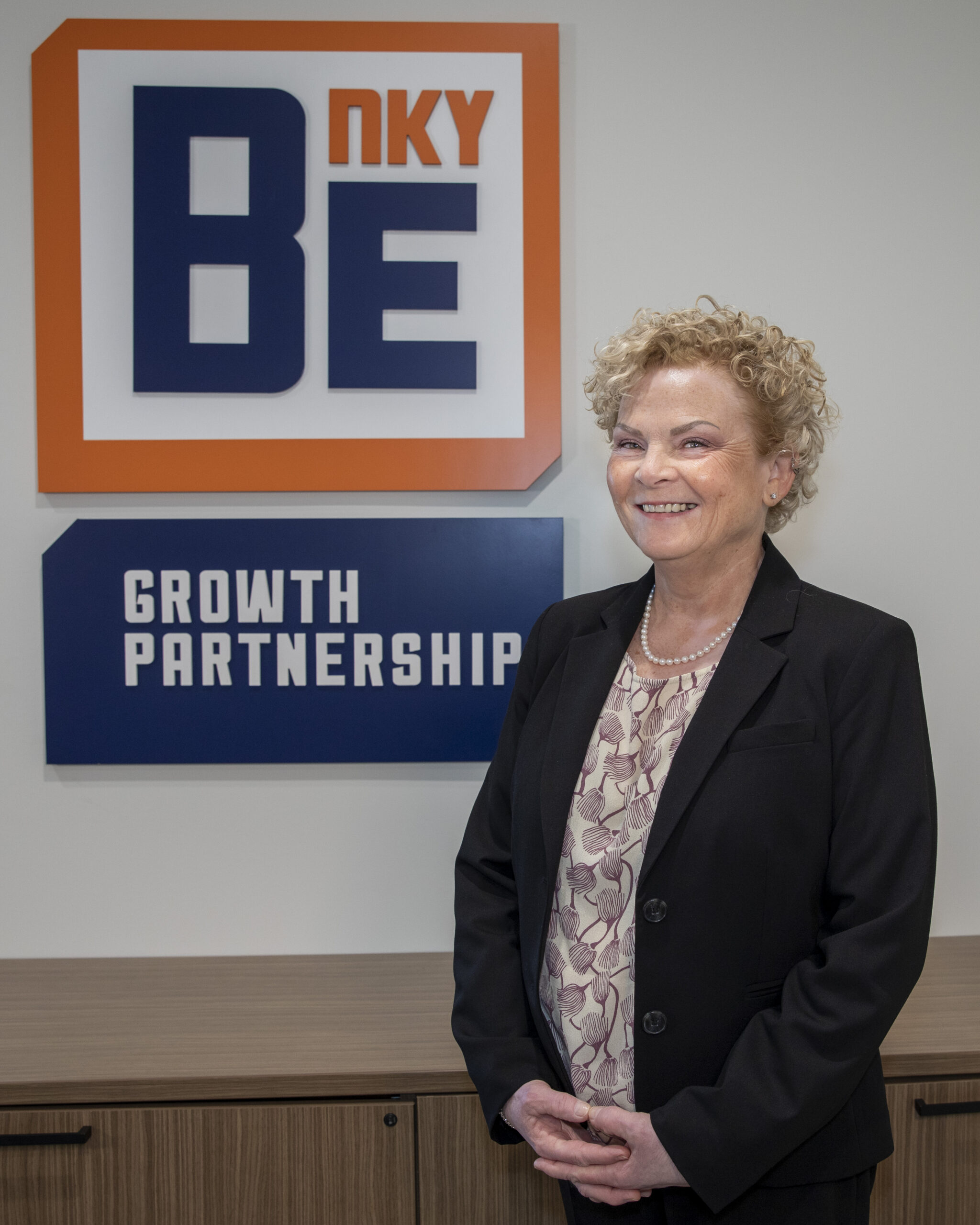 Tracy Power photo in front of BE NKY Growth Partnership sign