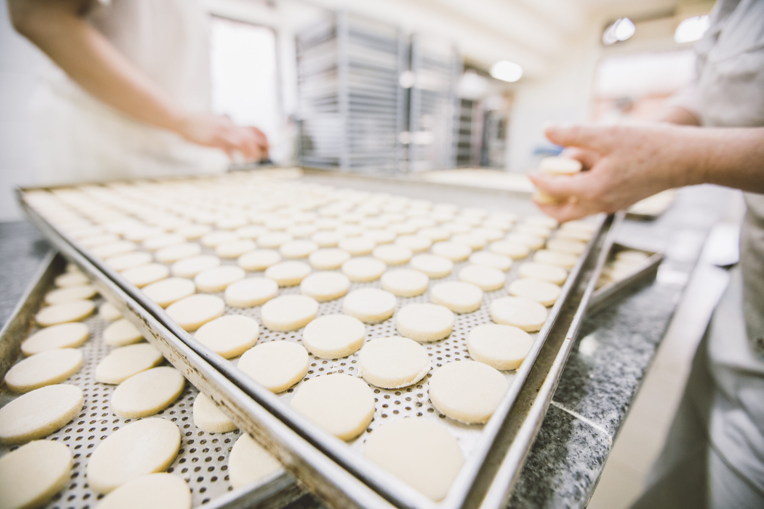 food and beverage manufacturing Two women working together in bakery, making food.